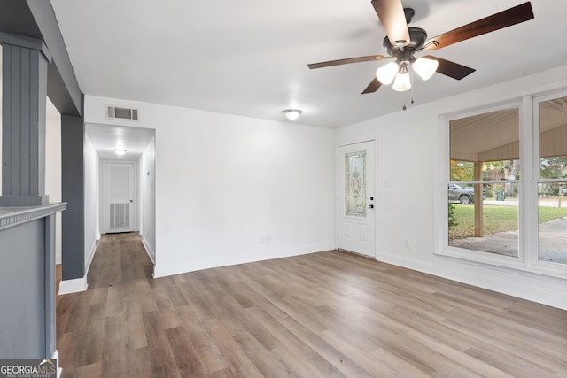 empty room with ceiling fan, lofted ceiling, and light hardwood / wood-style flooring