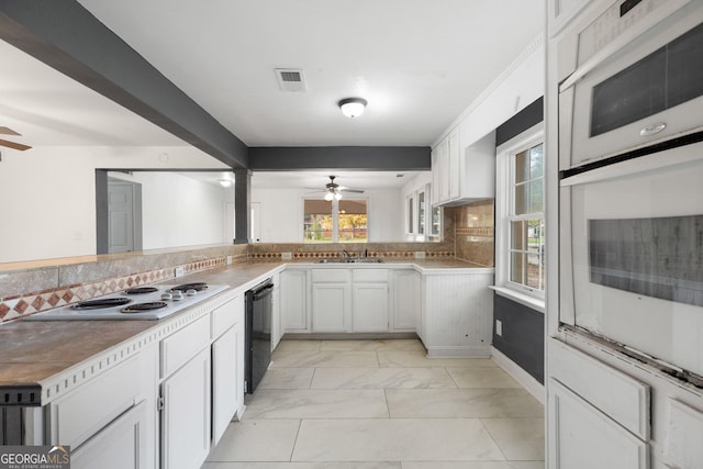 kitchen featuring decorative backsplash, white appliances, ceiling fan, sink, and white cabinets