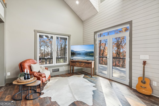 sitting room featuring high vaulted ceiling, french doors, and hardwood / wood-style flooring