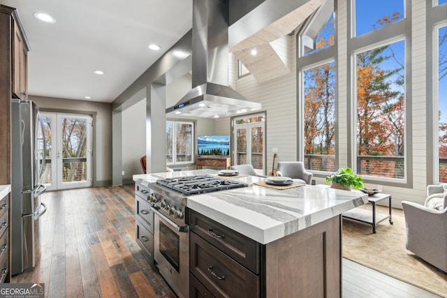 kitchen with stainless steel appliances, dark hardwood / wood-style flooring, a kitchen island, dark brown cabinets, and island range hood