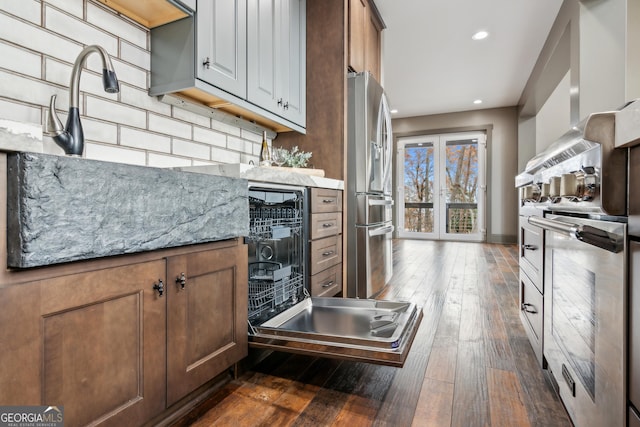 kitchen with light stone countertops, backsplash, stainless steel fridge, and dark hardwood / wood-style floors