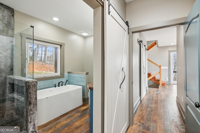 bathroom with a bath and hardwood / wood-style flooring