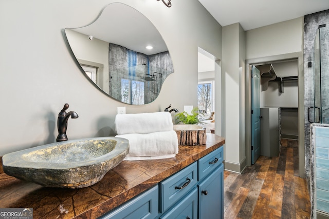 bathroom with vanity, walk in shower, and hardwood / wood-style floors