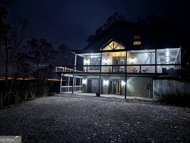 back house at night featuring a patio