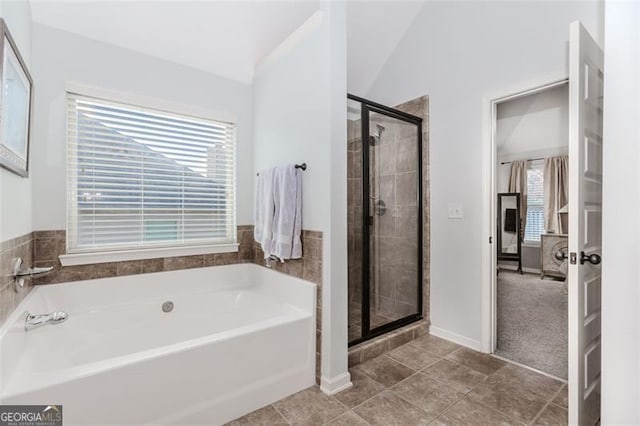 bathroom with separate shower and tub, vaulted ceiling, and a healthy amount of sunlight