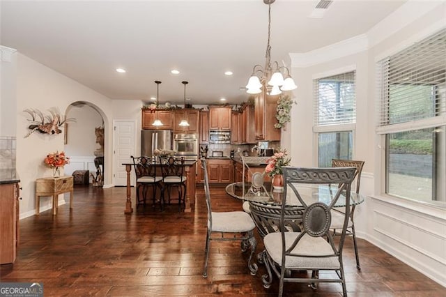 dining area with crown molding, a chandelier, and dark hardwood / wood-style floors