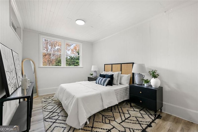 bedroom featuring crown molding and light wood-type flooring