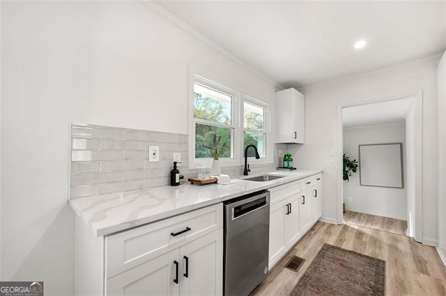 kitchen with white cabinetry, sink, light hardwood / wood-style flooring, stainless steel dishwasher, and decorative backsplash