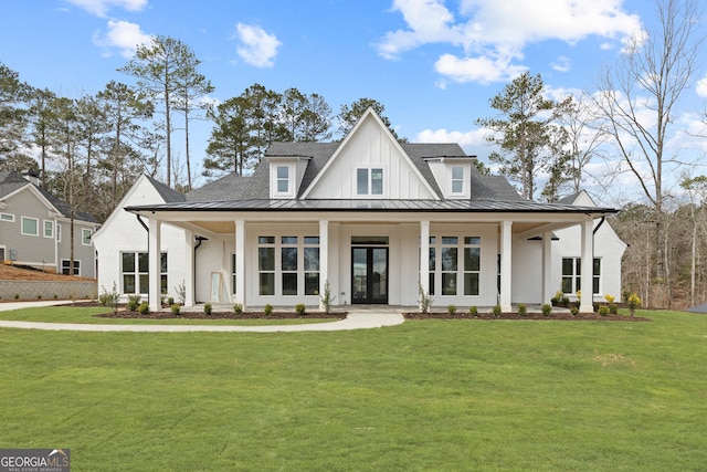 modern farmhouse style home featuring a standing seam roof, a front lawn, and board and batten siding