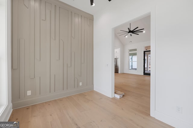 spare room featuring ceiling fan, vaulted ceiling, and light wood-style flooring