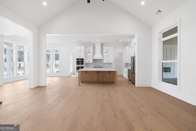 kitchen featuring light countertops, visible vents, appliances with stainless steel finishes, white cabinets, and premium range hood