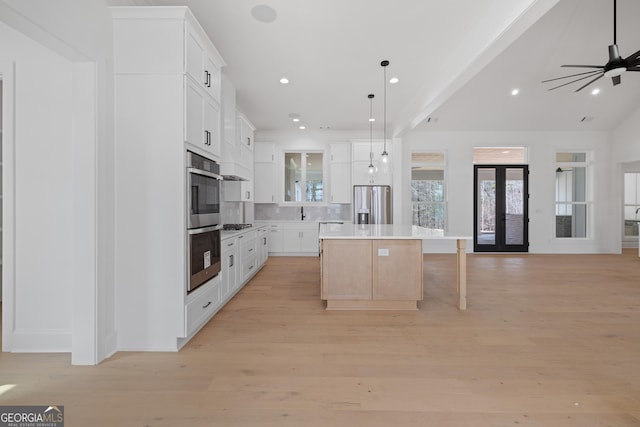 kitchen featuring a center island, open floor plan, french doors, and stainless steel fridge with ice dispenser