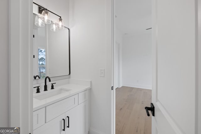 bathroom with wood finished floors, vanity, and baseboards