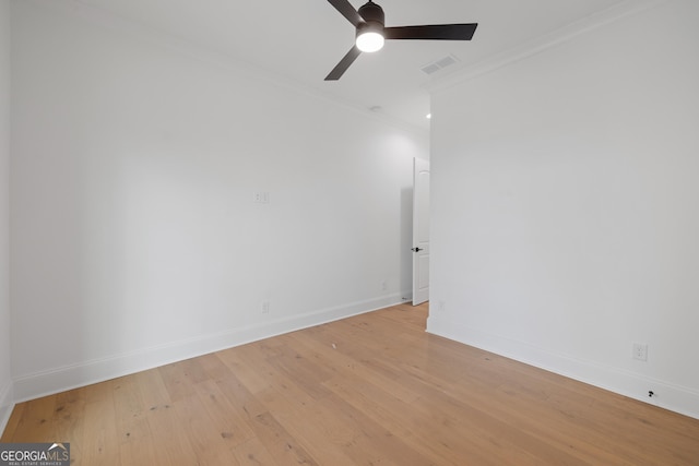 spare room with crown molding, visible vents, light wood-style floors, ceiling fan, and baseboards