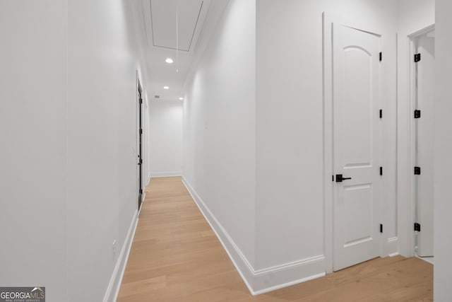 hall with light wood finished floors, attic access, baseboards, and recessed lighting