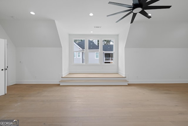 additional living space with visible vents, vaulted ceiling, baseboards, and wood finished floors