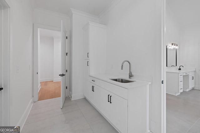 bathroom featuring baseboards, ornamental molding, and vanity