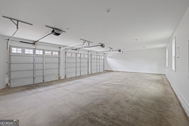 garage featuring a garage door opener and baseboards