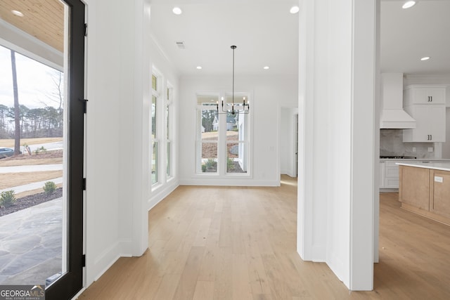 unfurnished dining area with visible vents, baseboards, an inviting chandelier, light wood-type flooring, and recessed lighting