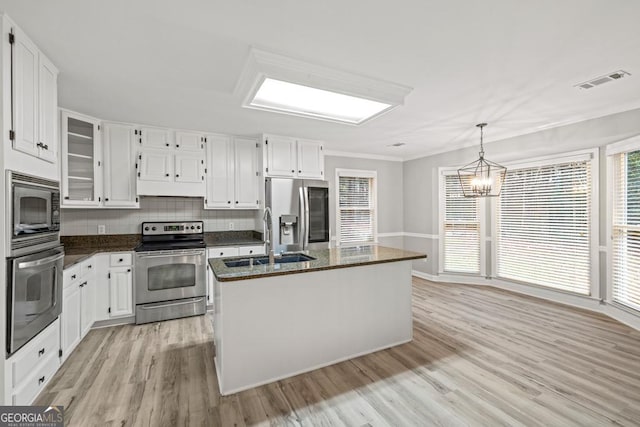 kitchen featuring white cabinets, stainless steel appliances, light hardwood / wood-style floors, and an island with sink