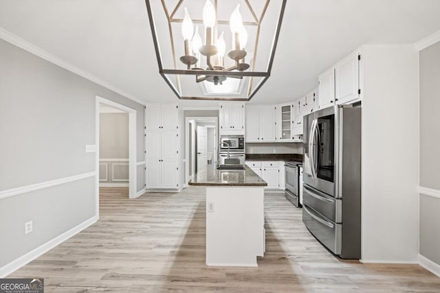 kitchen featuring white cabinets, a center island, appliances with stainless steel finishes, and a chandelier