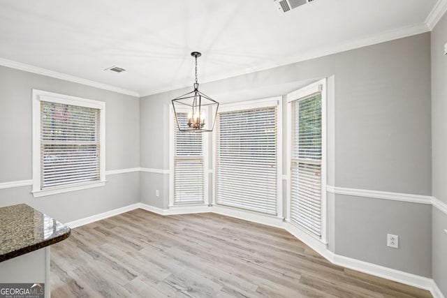 unfurnished dining area featuring crown molding, light hardwood / wood-style flooring, and a healthy amount of sunlight