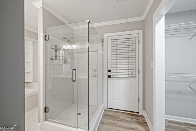 bathroom featuring hardwood / wood-style flooring, a shower with door, and crown molding