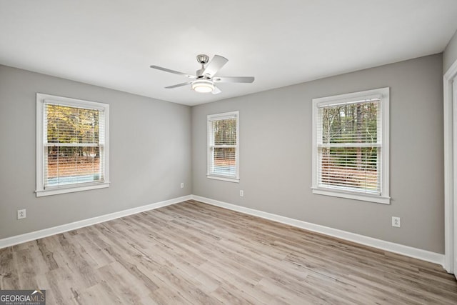 spare room with ceiling fan, a wealth of natural light, and light hardwood / wood-style flooring