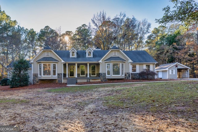 view of front facade featuring an outbuilding, covered porch, and a garage