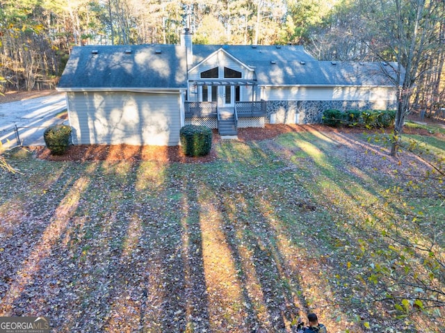 ranch-style home with a deck and a front lawn