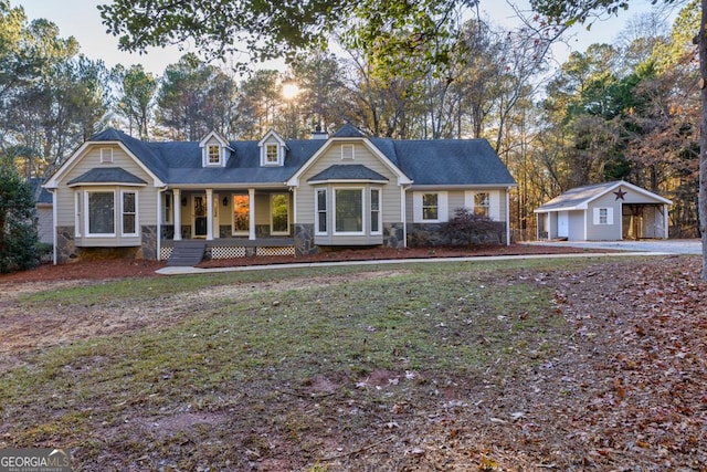 view of front of house with an outbuilding, a front lawn, a porch, and a garage