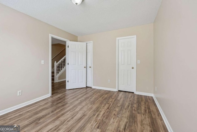 unfurnished bedroom featuring wood-type flooring and a textured ceiling