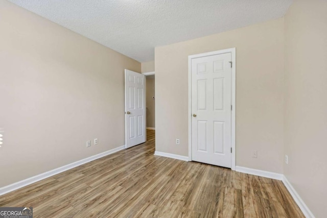 unfurnished bedroom with wood-type flooring and a textured ceiling