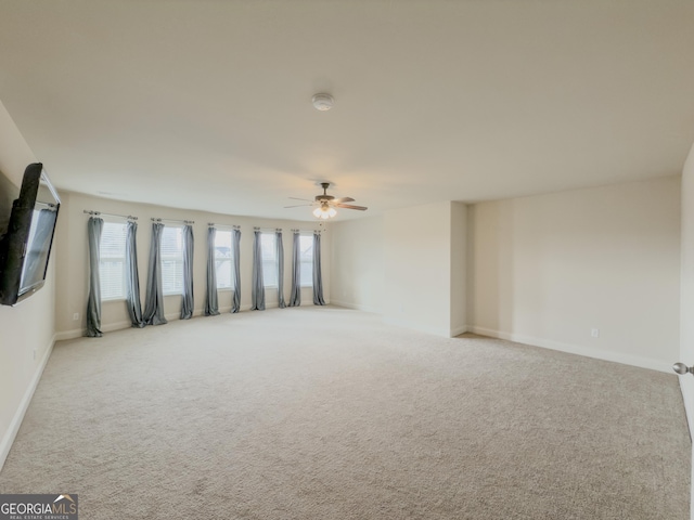 carpeted spare room featuring ceiling fan