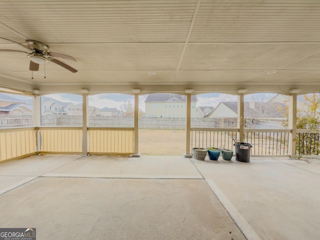 unfurnished sunroom featuring ceiling fan