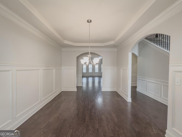 unfurnished dining area with ornamental molding, dark hardwood / wood-style flooring, a raised ceiling, and a notable chandelier