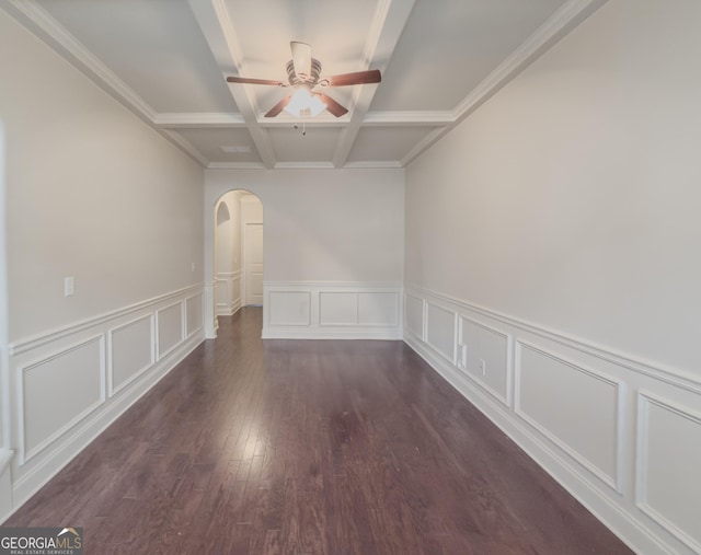 spare room featuring dark wood-type flooring, coffered ceiling, crown molding, ceiling fan, and beamed ceiling