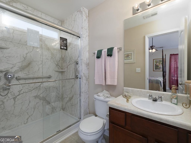 bathroom featuring ceiling fan, a shower with door, vanity, and toilet