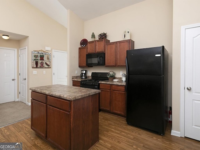 kitchen with a center island, dark hardwood / wood-style floors, and black appliances