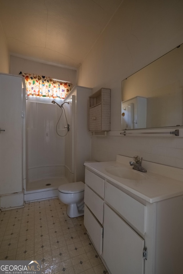 bathroom with toilet, vanity, and walk in shower