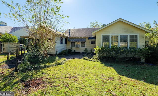 back of property featuring a lawn