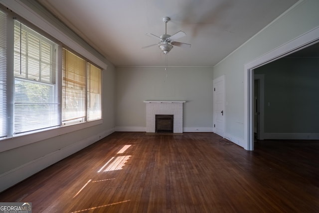 unfurnished living room featuring dark hardwood / wood-style floors, ceiling fan, crown molding, and a fireplace