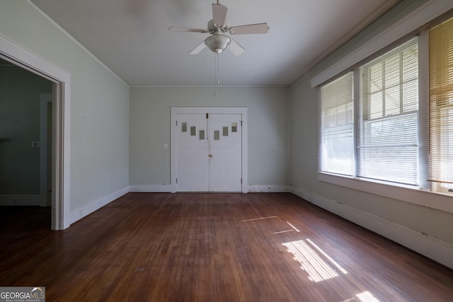 empty room with dark hardwood / wood-style floors, ceiling fan, and crown molding