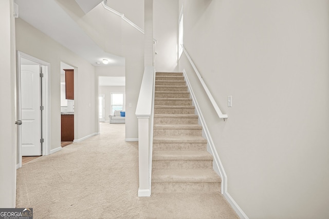 stairs featuring carpet flooring and baseboards