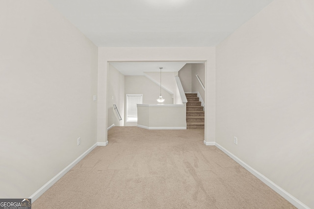 spare room featuring carpet and baseboards