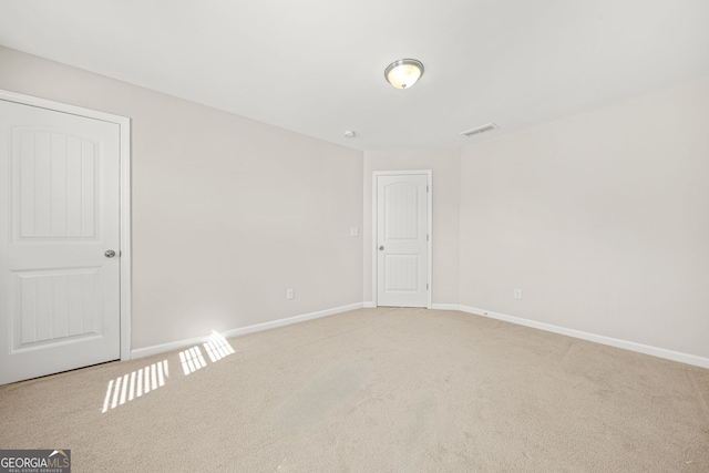 empty room with light carpet, baseboards, and visible vents