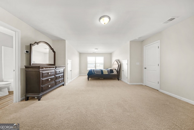 bedroom with connected bathroom, carpet flooring, visible vents, and baseboards