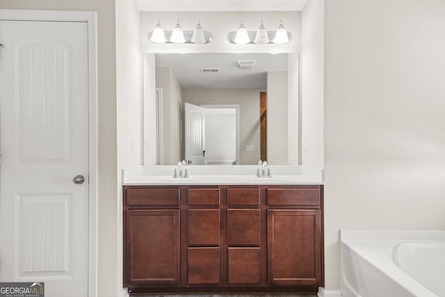 bathroom featuring a sink, double vanity, visible vents, and a bath