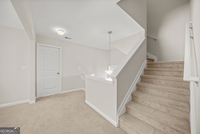 stairs featuring carpet floors, visible vents, and baseboards