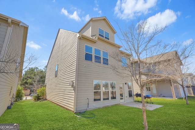 rear view of property featuring a yard and a patio area